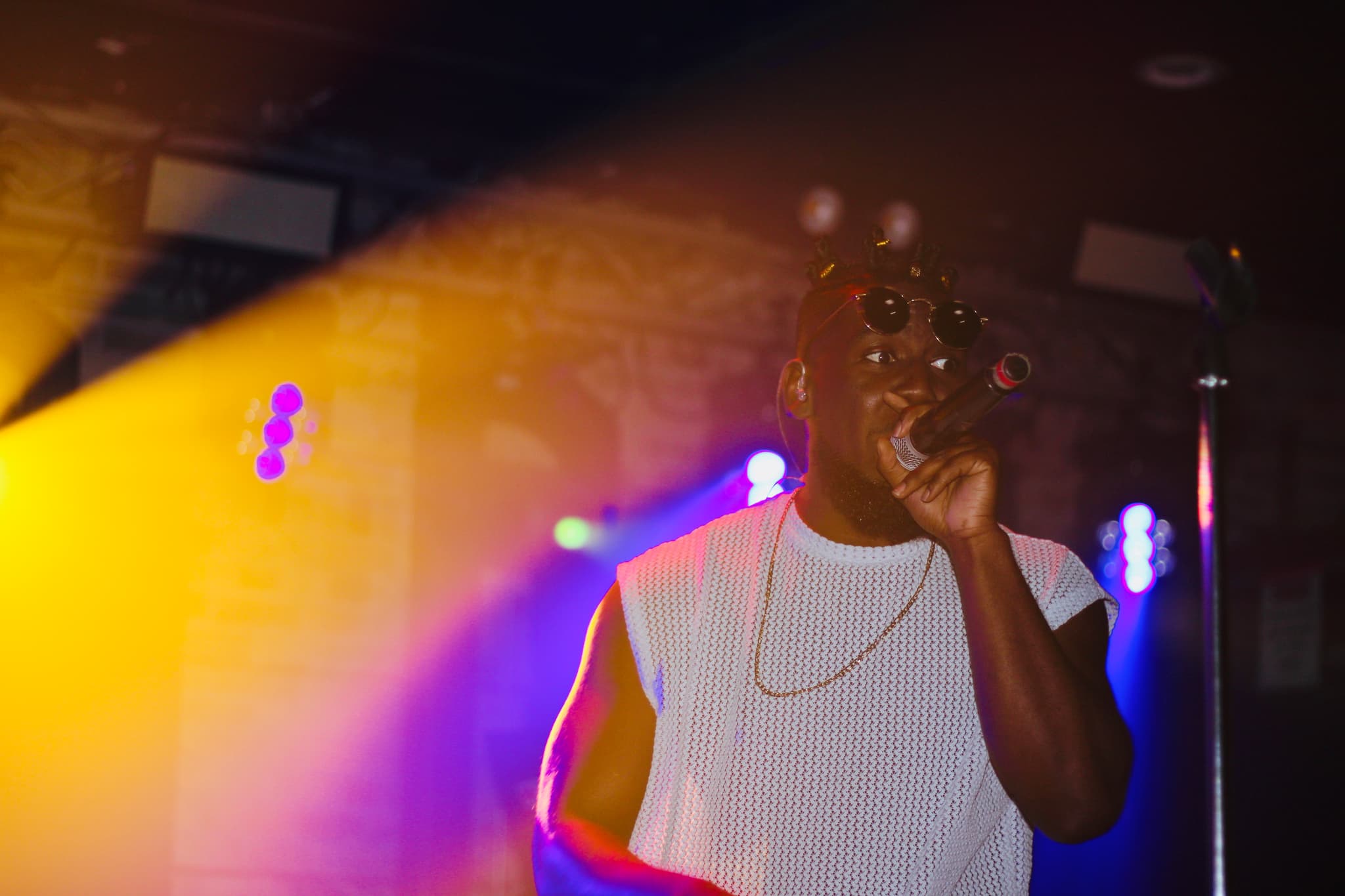 Live concert atmosphere with dramatic stage lighting and energetic crowd