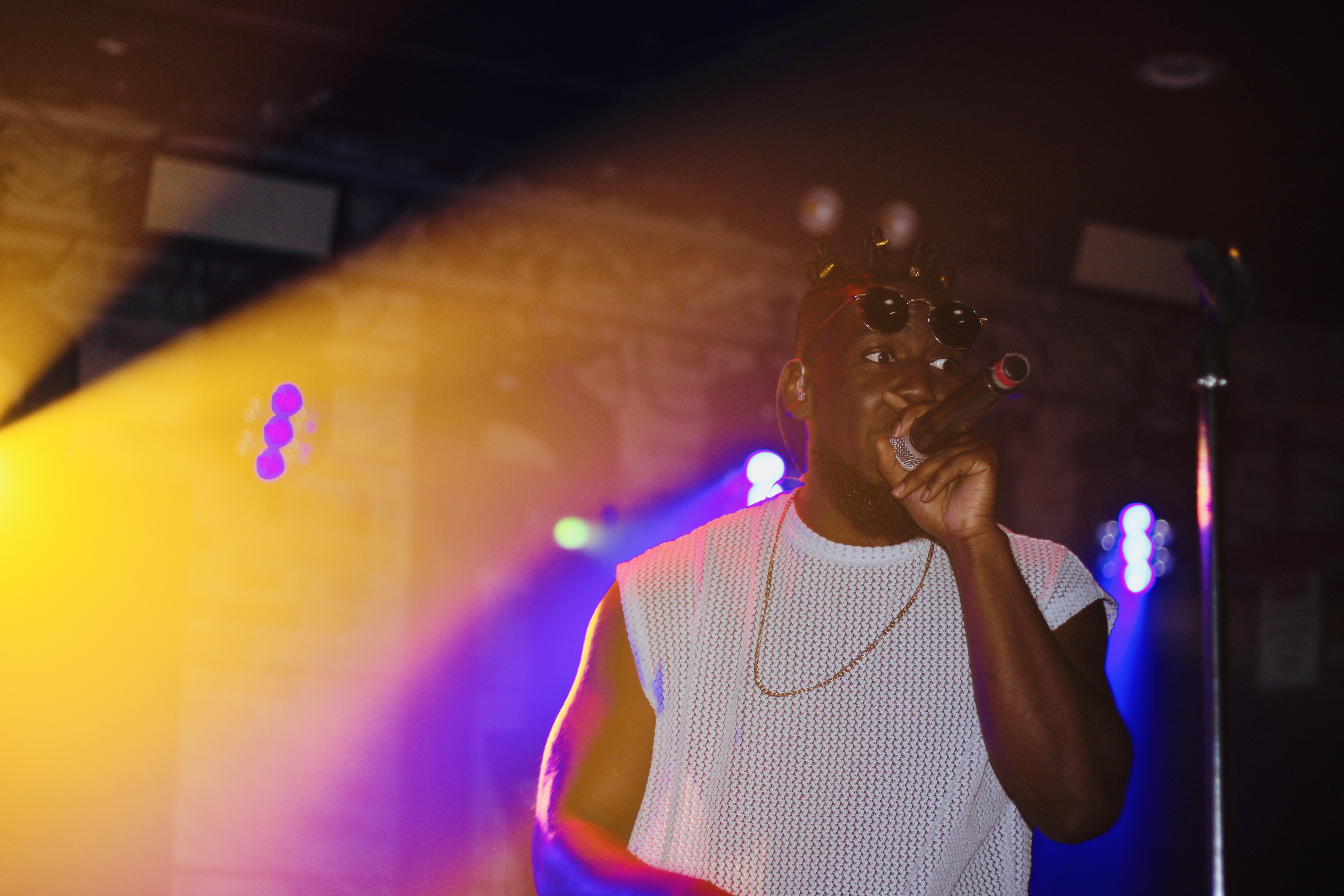 Live concert atmosphere with dramatic stage lighting and energetic crowd